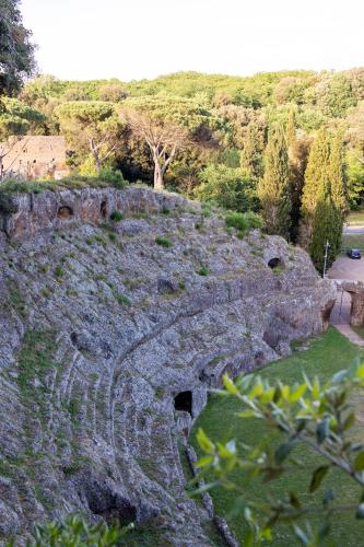 an old amphitheater on a hill with grass and trees at Radici Etrusche Sutri in Sutri