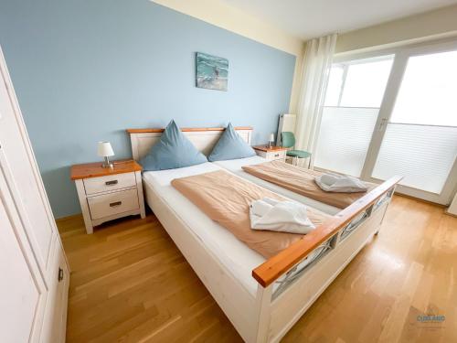 una camera da letto con un letto grande con pareti blu di Haus Blue Ocean Wohnung 8 a Cuxhaven