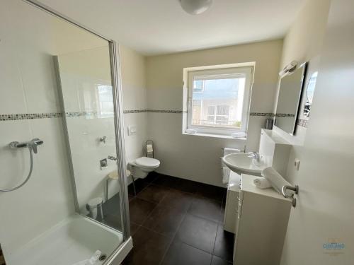 un bagno con doccia, WC e lavandino di Haus Blue Ocean Wohnung 8 a Cuxhaven