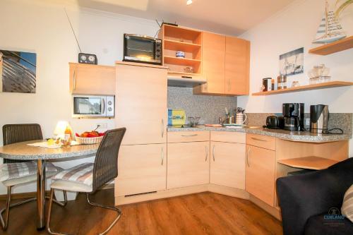 クックスハーフェンにあるStrand und zentrumsnahe Ferienwohnung für bis zu 2 Personen in Döseのキッチン(木製キャビネット、テーブル付)
