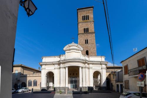 a large white building with a tall tower at Radici Etrusche Sutri in Sutri