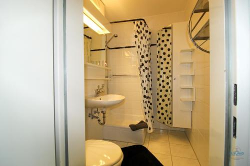 Un baño pequeño con inodoro y lavabo. en Urlaub mit spektakulärer Aussicht auf das Wattenmeer, en Cuxhaven