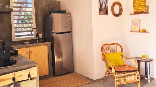 a kitchen with a refrigerator and a chair and a table at 12 Casa Hermanito in Kralendijk