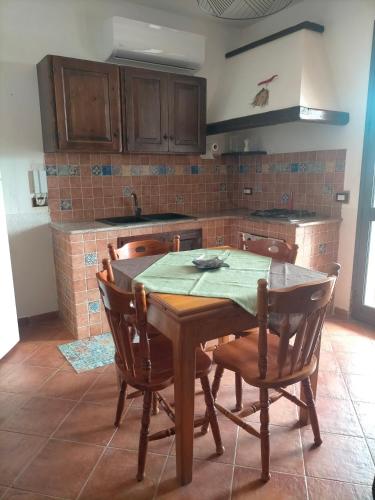 a kitchen with a wooden table and chairs at Menzel el Emir in Misilmeri