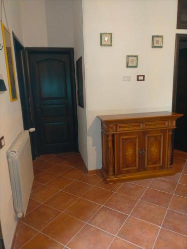 a room with a door and a tiled floor with a wooden cabinet at Menzel el Emir in Misilmeri