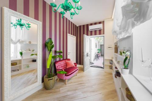 a living room with a pink and white striped wall at It’s Room in Naples