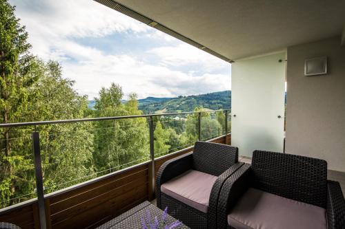a balcony with two chairs and a view of the mountains at Apartview Bukowa II by Rent like home in Wisła