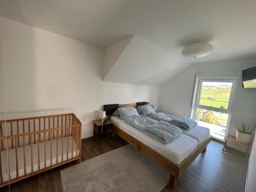 a bedroom with a bed and a window at 3 Zimmer Neubauwohnung in der schwäbischen Toskana in Löwenstein