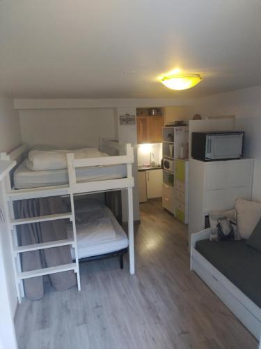 une petite chambre avec deux lits superposés et un canapé dans l'établissement Jolie studio en RDC, à Cauterets