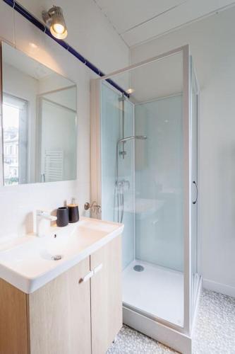 une salle de bain avec un lavabo et une douche en verre dans l'établissement L'Ecume - Maison avec terrasse à 50m de la mer, à Étretat