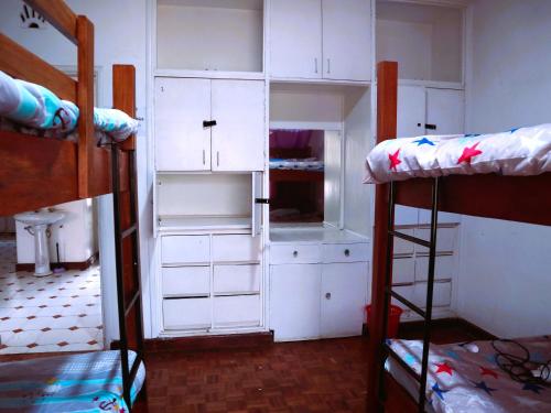 a room with two bunk beds and white cabinets at Jabulani Nairobi Backpackers Hostel in Nairobi
