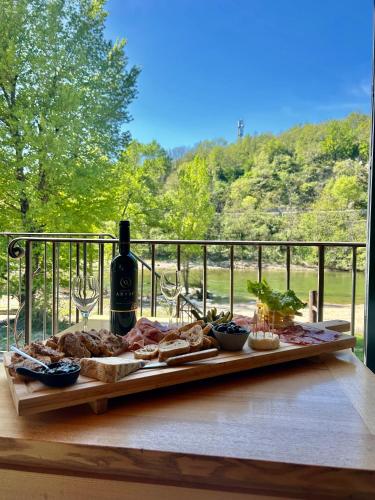 - une table avec de la nourriture et une bouteille de vin dans l'établissement Maison de Village Chez Popeye, à Vogüé