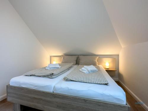 a bed in a room with two pillows on it at Refugium Storchenwiese Wohnung 2 in Cuxhaven