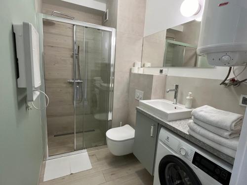 a bathroom with a shower and a toilet and a sink at APARTAMENTY MIERZEJA - STEGNA PARK STUDIO, 500 m od plaży, bezpłatny meleks in Stegna