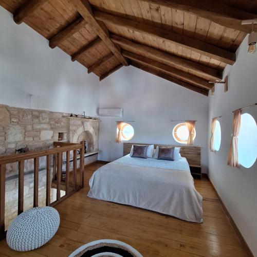 a bedroom with a large bed and wooden ceilings at To Pefko - Mezzanines - in Meyisti