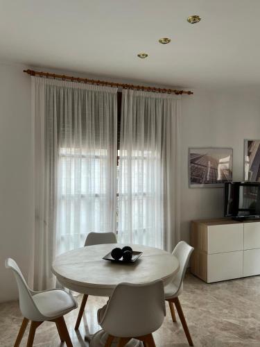 a white dining room with a table and chairs at Quererte in Teruel