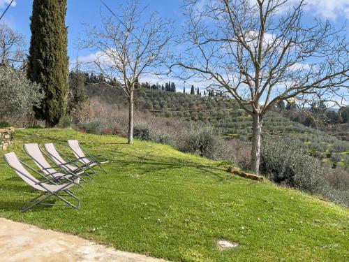 two white chairs sitting on a grassy hill with trees at B&B Non ti scordar di me in Arezzo
