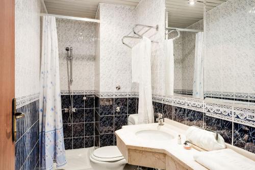 a bathroom with a sink and a toilet and a mirror at Amber-Rose Apart Hotel in Alanya