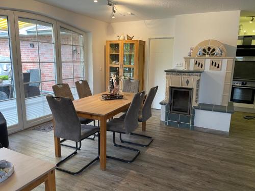 a dining room with a table and chairs and a fireplace at Skippersin5 in Greetsiel