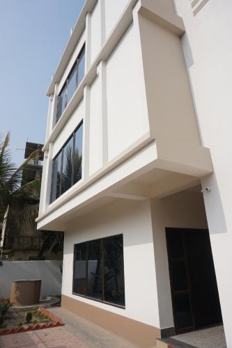a white house with a lot of windows at The Urban Escape in Guwahati