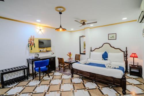 a bedroom with a bed and a desk and a television at Ramas Resort in Nawai