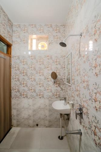 a bathroom with a sink and floral wallpaper at Ramas Resort in Nawai