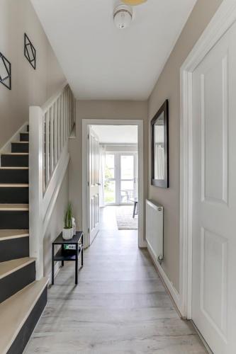 a hallway of a home with a staircase and a door at Modern, spacious house near town in Peterborough
