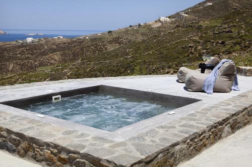 a pool of water sitting on top of a mountain at Villa Amra - Secluded Mykonos Haven with Sea Views, Heated Pool, Gym & Hammam in Elia