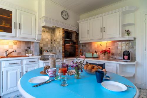 une cuisine avec une table bleue et de la nourriture. dans l'établissement Maison proche mer et centre, à Audierne