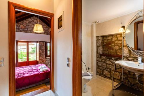 a bathroom with a bed and a sink and a mirror at Stone Villas Dukes in Paralion astros