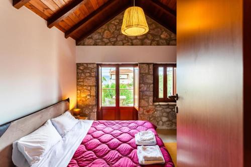 a bedroom with a pink bed and a window at Stone Villas Dukes in Paralion astros