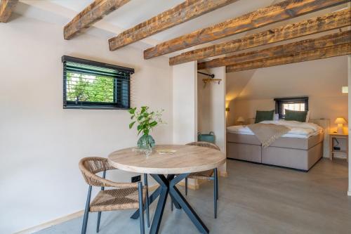 a room with a table and a bed at Bed en Wijn - Suite Landhuisje in Staphorst