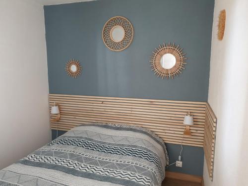 une chambre avec trois miroirs sur un mur bleu dans l'établissement Appartement vue port, à Capbreton