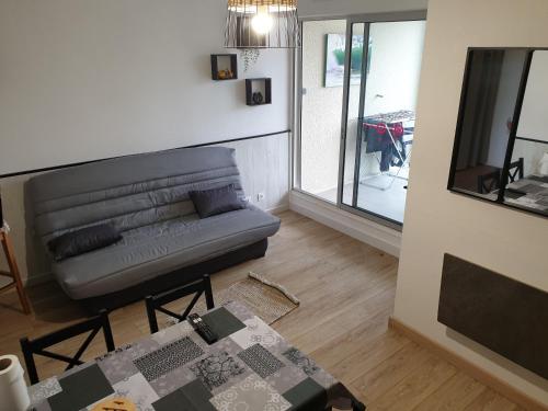 un salon avec un canapé en cuir et une table dans l'établissement Appartement vue port, à Capbreton