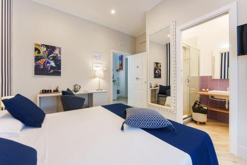 a bedroom with a large white bed and a bathroom at It's Room Naples in Naples