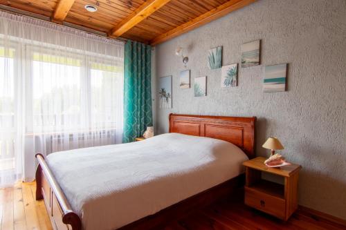 a bedroom with a large bed and a window at Agroturystyka Katarzyna Tarasiewicz in Stary Folwark