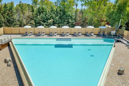 a swimming pool with chairs and umbrellas at Sabhé Gallipoli in Gallipoli
