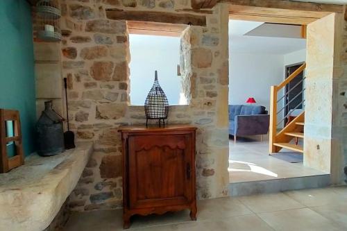 - un salon avec un mur en pierre et une armoire en bois dans l'établissement Fermette Brionnaise, à Saint-Laurent-en-Brionnais