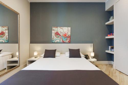 a bedroom with a large white bed and a mirror at It's Room Naples in Naples
