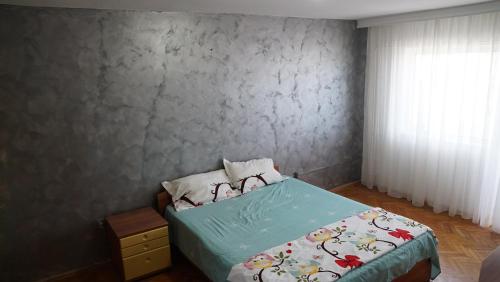 a bedroom with a bed with a blue comforter at Apart Portul Turistic in Mangalia