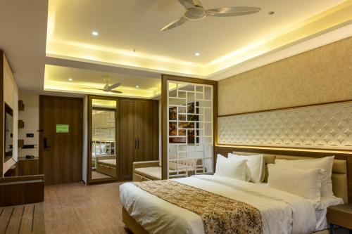a bedroom with a large bed with a ceiling fan at Hotel Mivaante in Ahmedabad