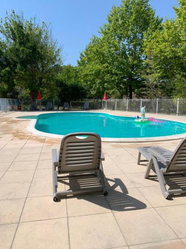 deux chaises longues assises à côté d'une piscine dans l'établissement L'orée des Landes, à Onesse-et-Laharie