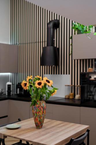 a vase with flowers on a wooden table in a kitchen at It's Room Naples in Naples