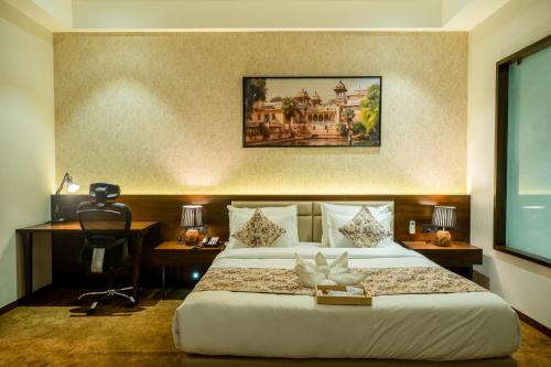 a hotel room with a bed and a desk and a desk at Hotel Mivaante in Ahmedabad