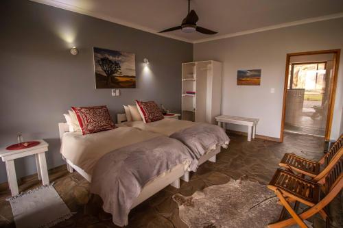 a bedroom with two beds and a window at Greenfire Desert Lodge in Maltah&ouml;he