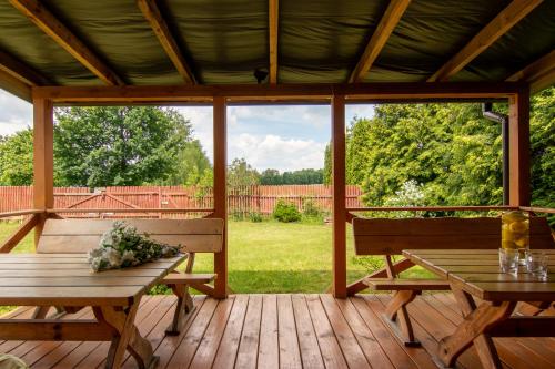 a screened in porch with two benches and a table at Agroturystyka Katarzyna Tarasiewicz in Stary Folwark