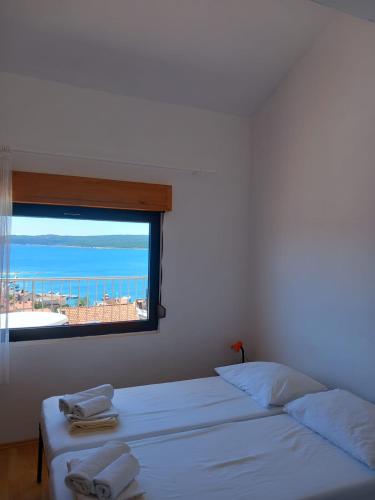 a bedroom with two beds and a window with the ocean at Orchid in Selce