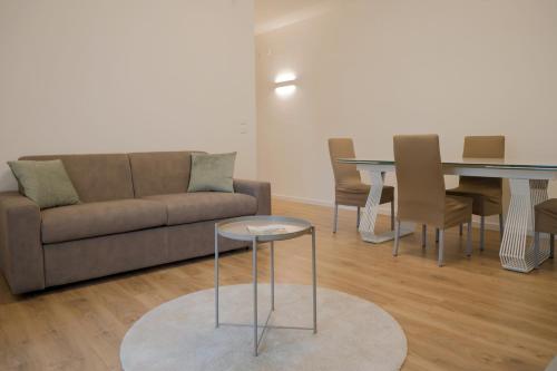 a living room with a couch and a table and chairs at Ca' Martha - A due passi dal centro con parcheggio privato - Aeroporto 2 chilometri in Treviso