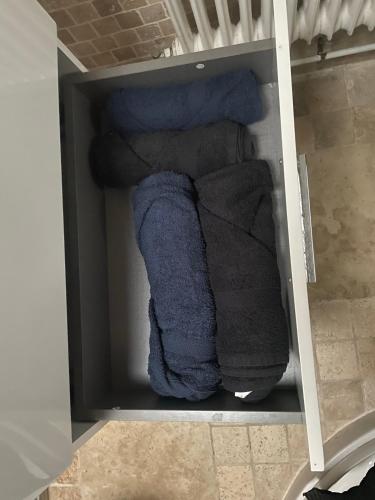 une étagère avec des serviettes et des torchons dans une pièce dans l'établissement Charmant logement à Romainville, à Romainville