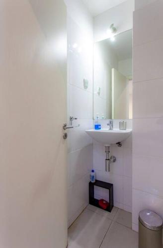 a white bathroom with a sink and a mirror at Alfama IV in Lisbon